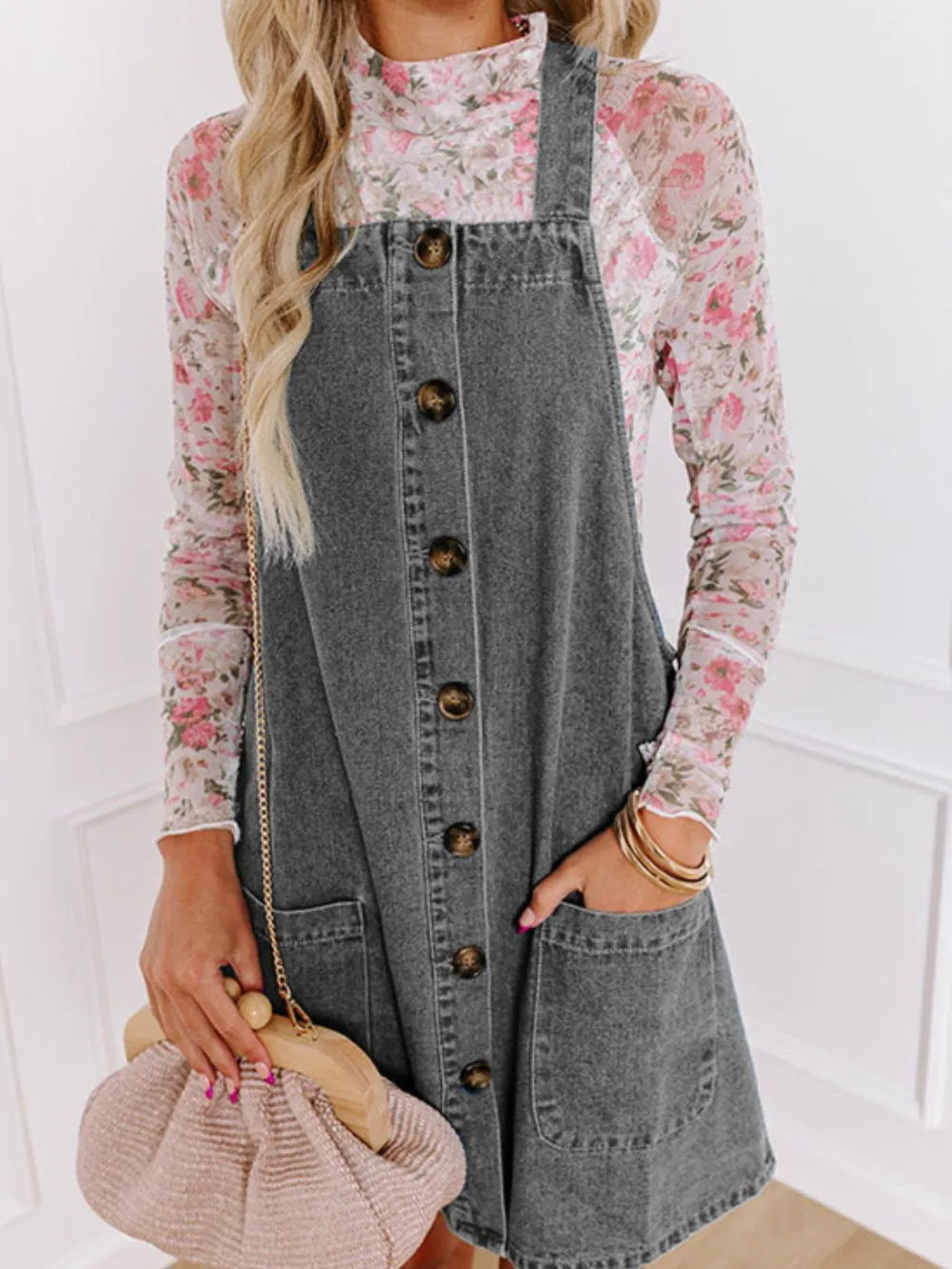 Wide Strap Button Down Denim Overall Dress worn over a floral top, showcasing a stylish casual outfit with buttons and pockets.
