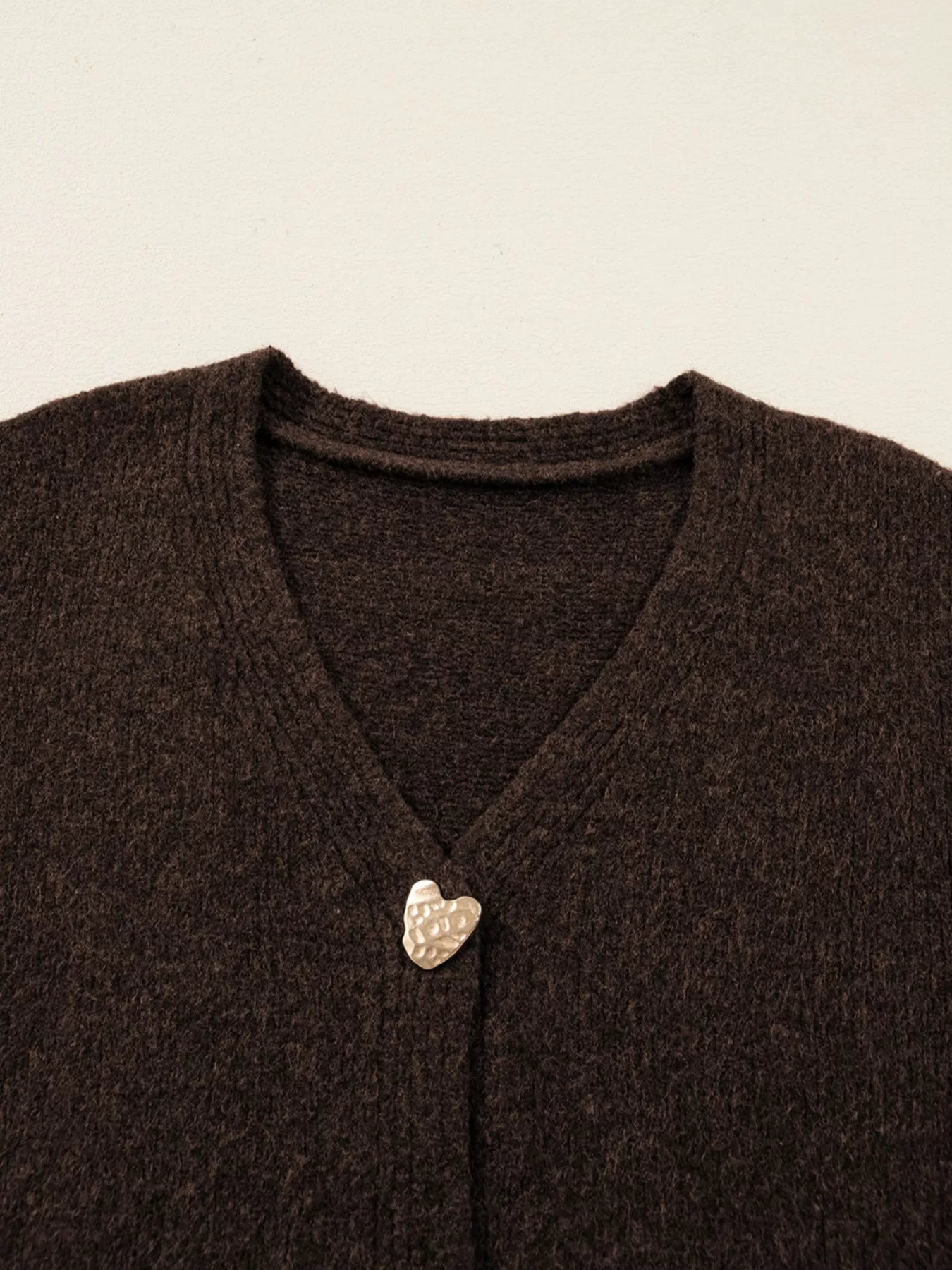 Heart Metal Button V Neck Cardigan Sweater featuring a silver heart button detail on a brown fabric.