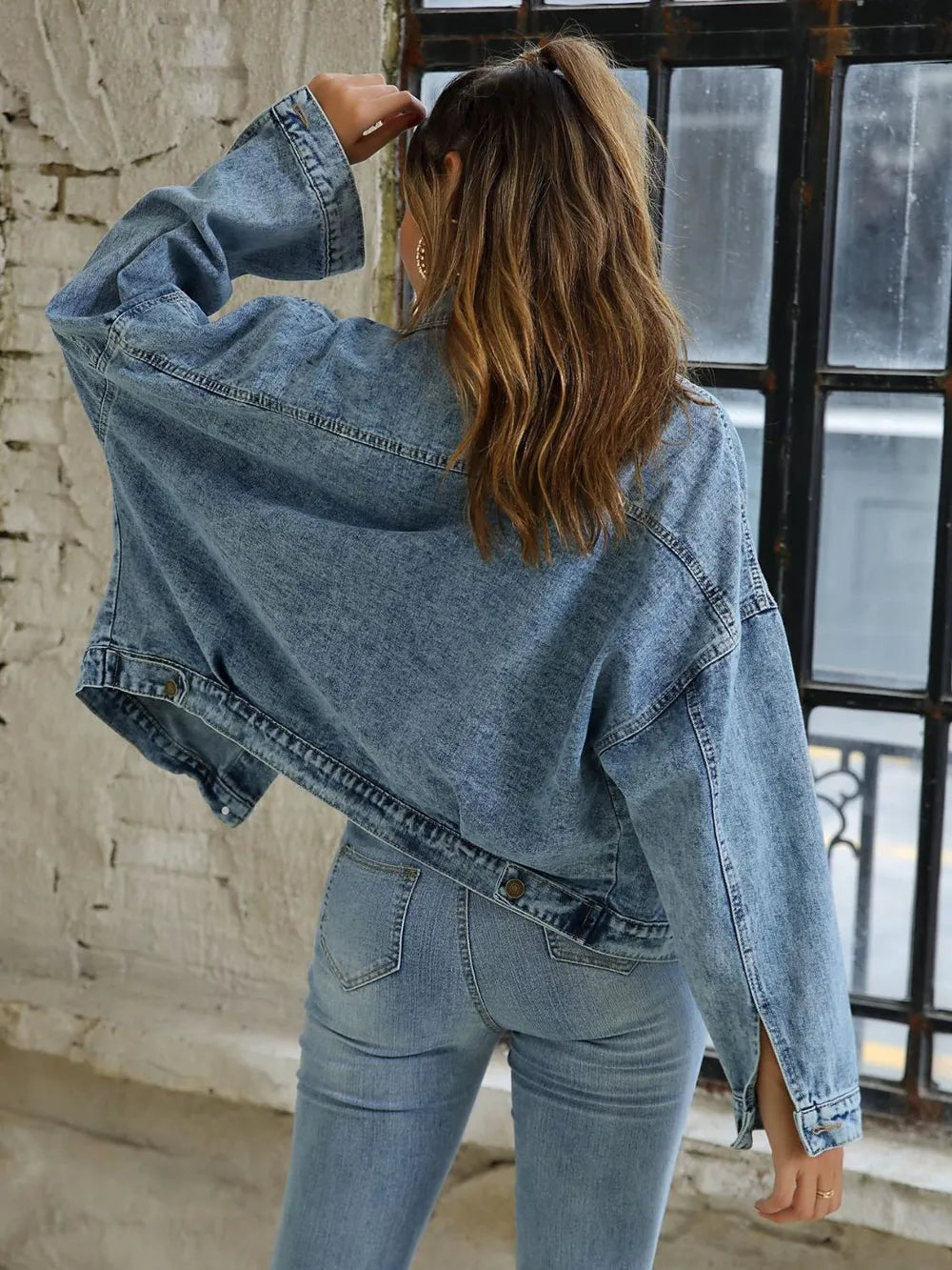 Back view of a woman wearing a Button Down Drop Shoulder Denim Jacket, perfect for casual layering.