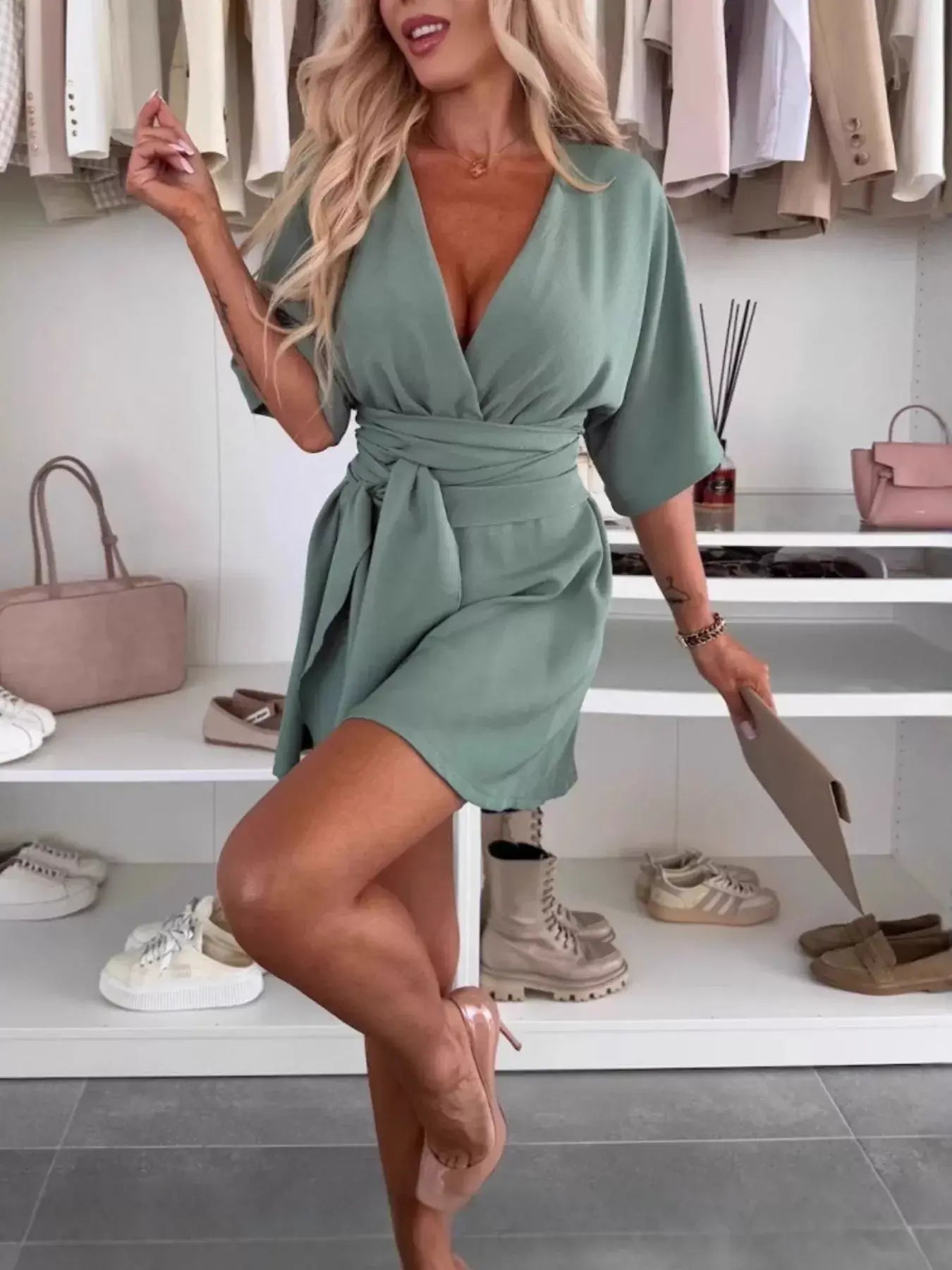 Model wearing a Full Size Surplice Tie Waist Romper in green, styled with a tie waist and relaxed fit.