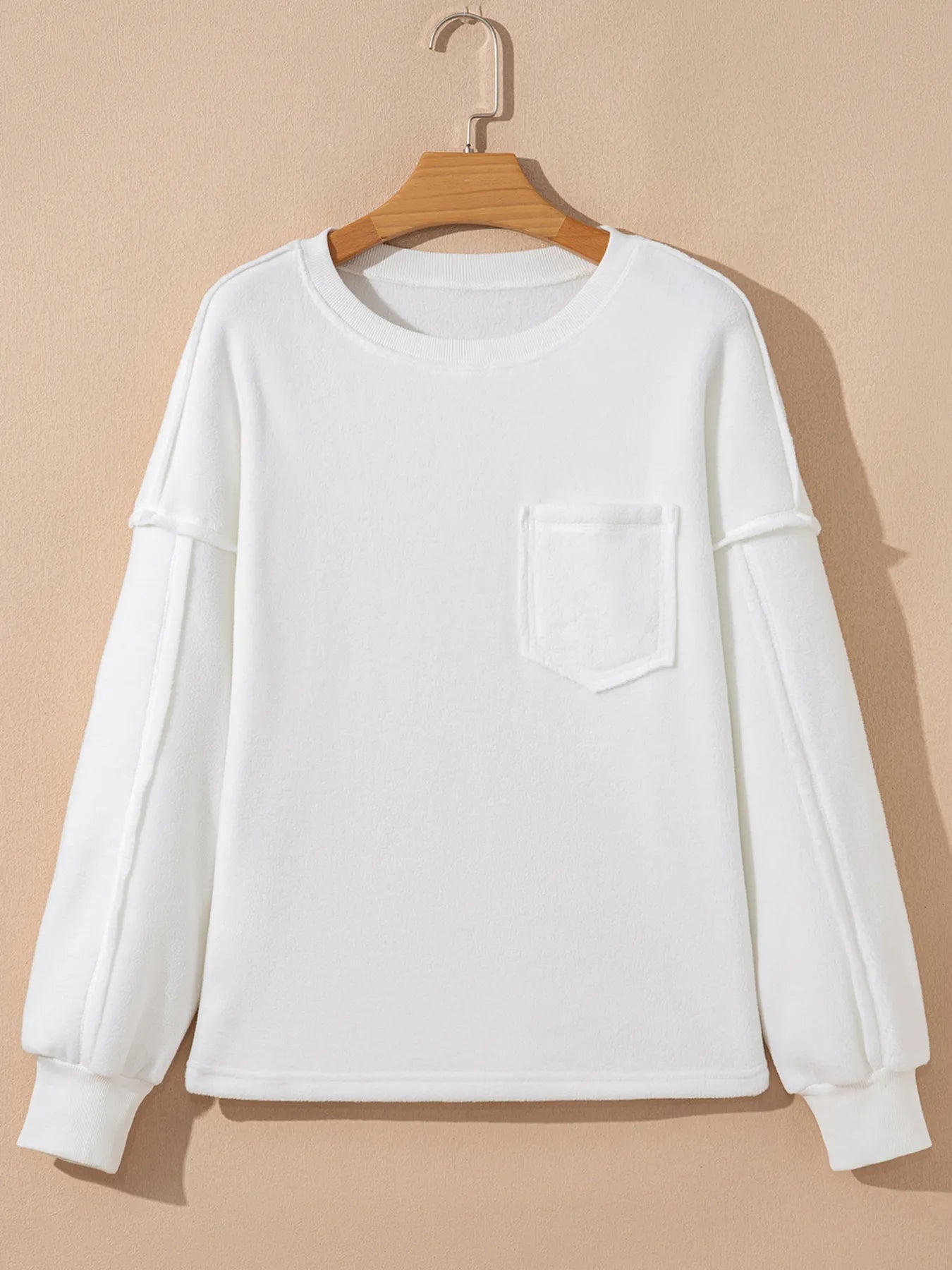 Exposed Seam Chest Pocket Knit Pullover Sweatshirt in white with a chest pocket and slightly stretchy fabric.