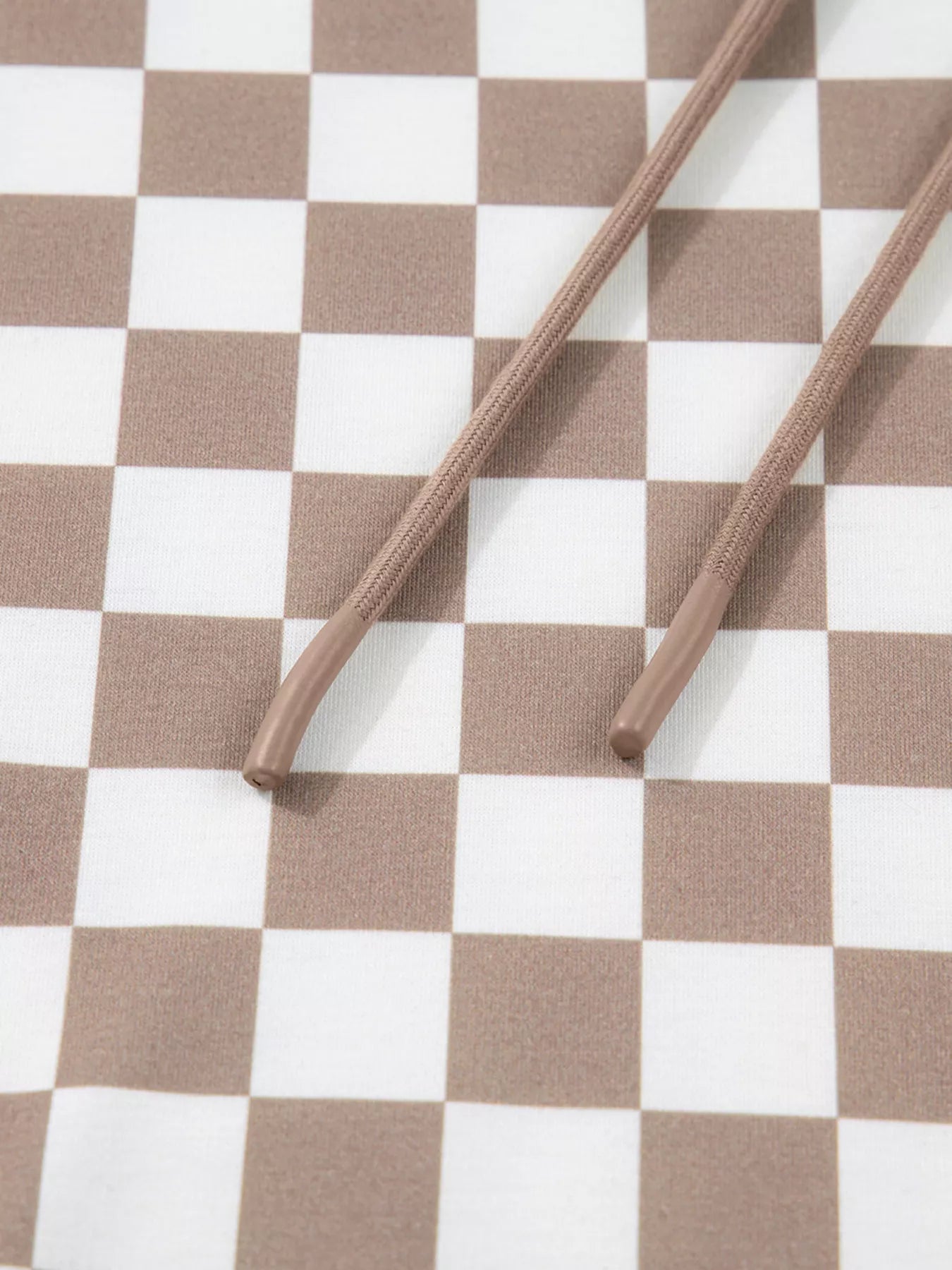 Checkered Pattern Oversized Drawstring Hoodie with brown drawstrings on a checkered background.
