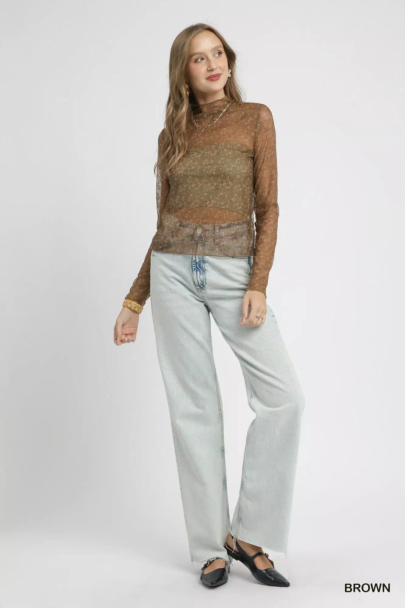 Woman wearing umgee nylon lace mesh long sleeve top with light blue jeans, showcasing elegant sheer style.