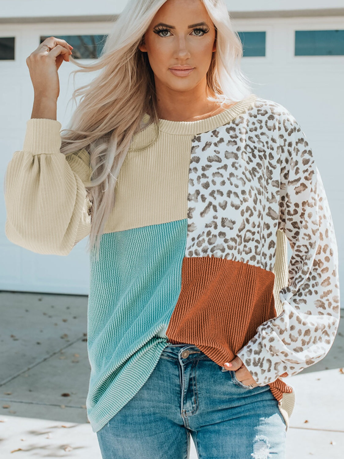 Model wearing a Color Block Leopard Round Neck Sweatshirt, featuring mixed colors and leopard print, styled casually.