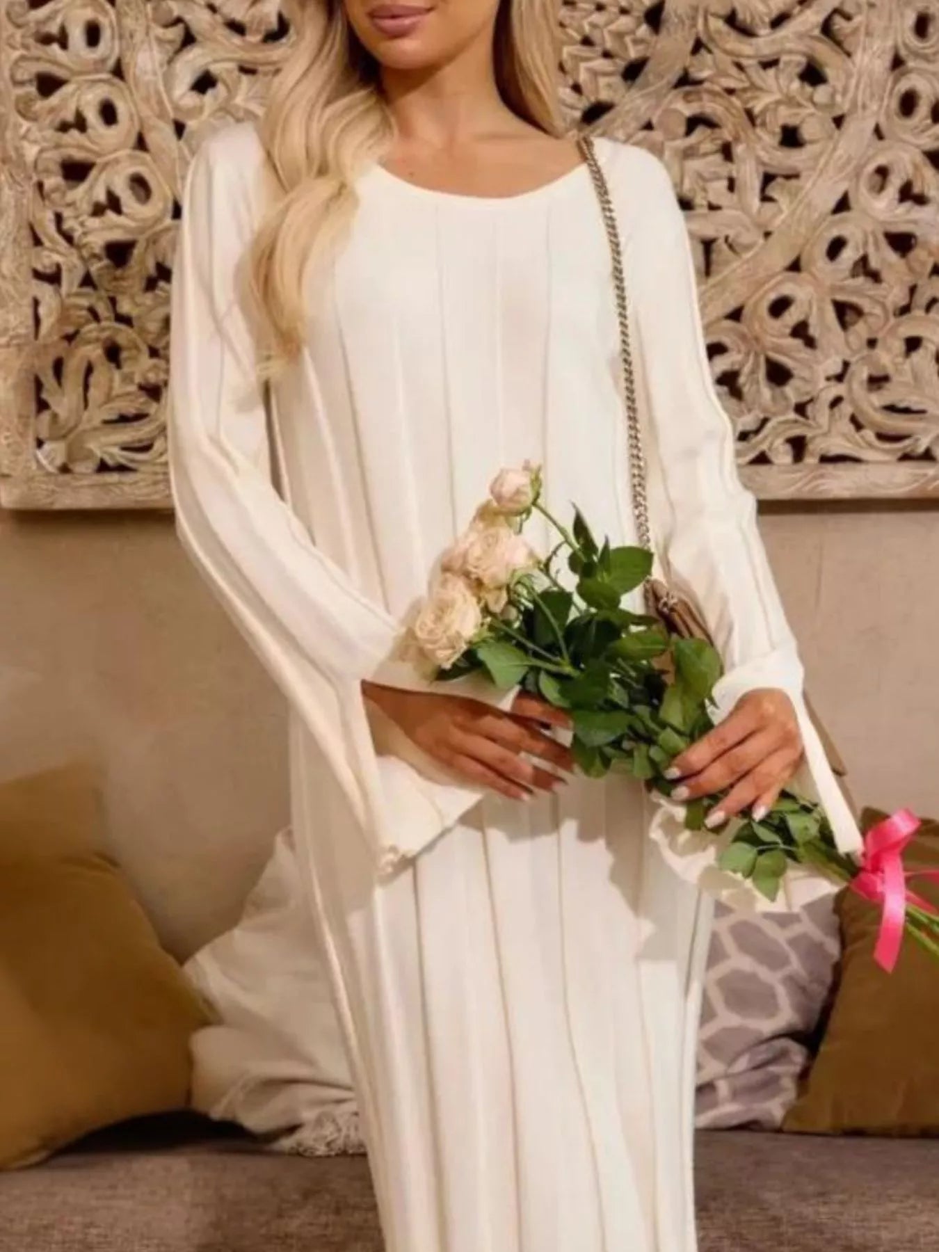 Ribbed Knit Slit Sweater Dress worn by a model, showcasing its elegant design and long sleeves with pleats.