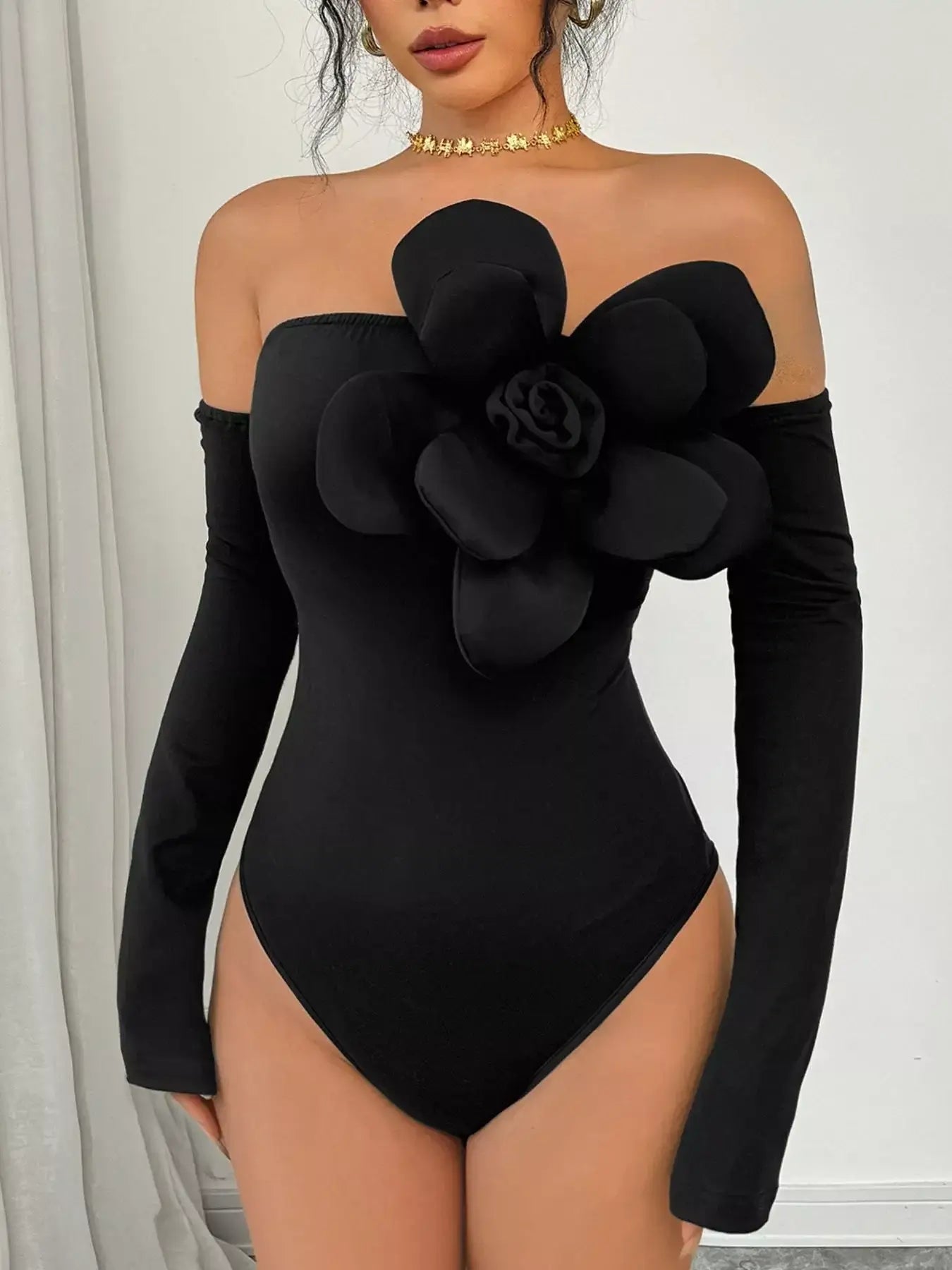 Flower off-shoulder long sleeve bodysuit in black with a floral detail, perfect for elegant styling.