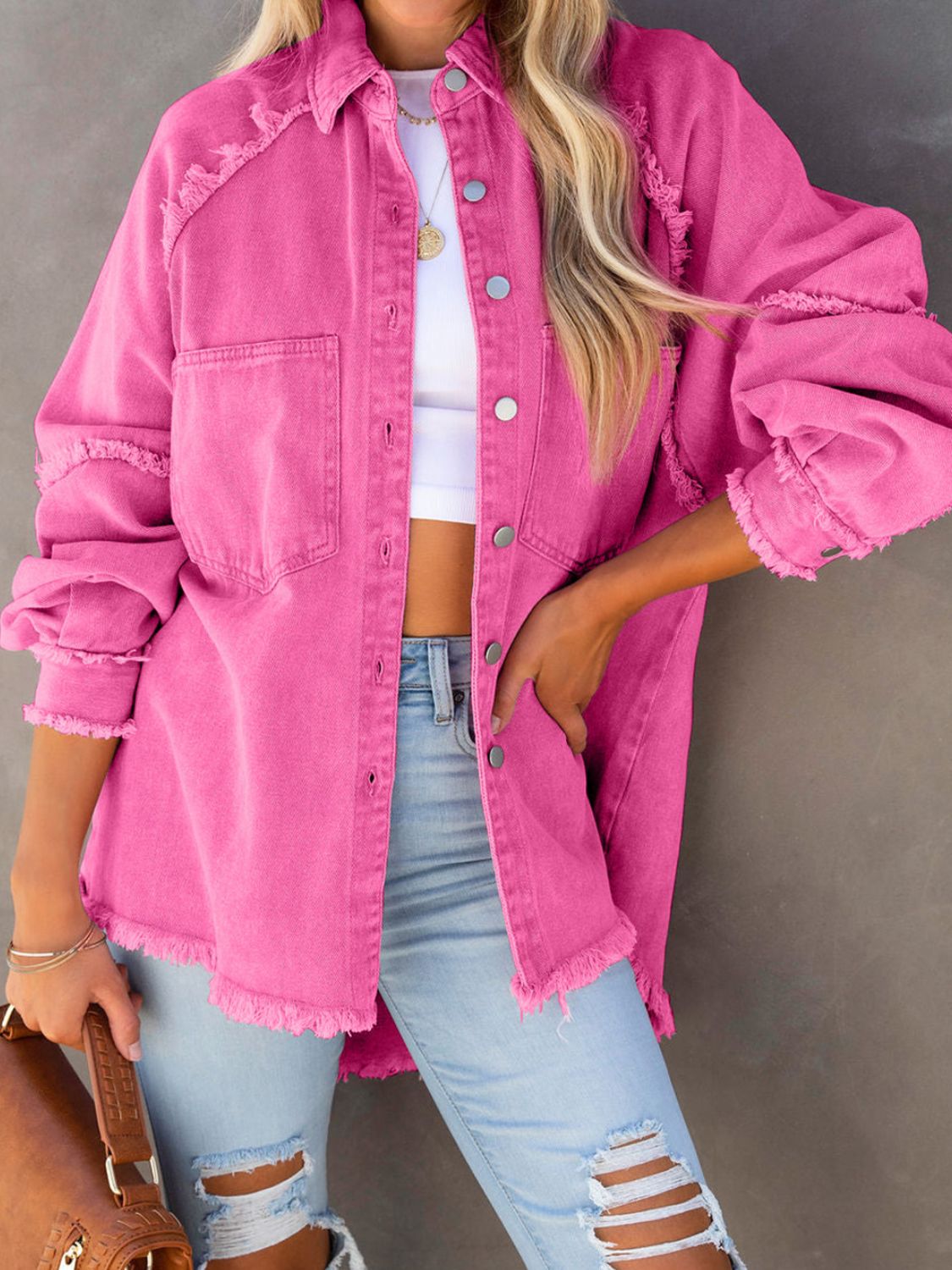Model wearing a Button Down Raw Hem Denim Jacket in pink with distressed details, paired with ripped jeans.