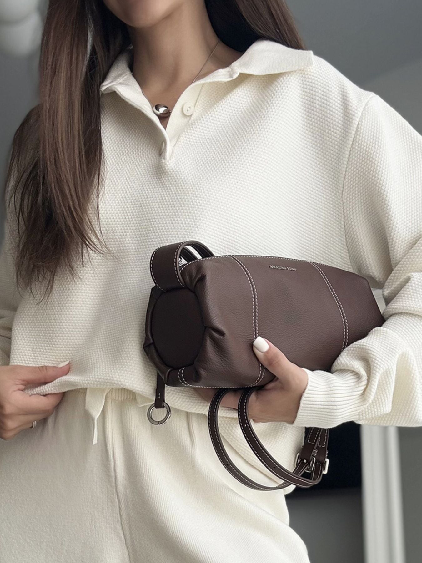 A woman wearing a white Polo Collar Knit Two Piece Set, holding a stylish brown handbag.