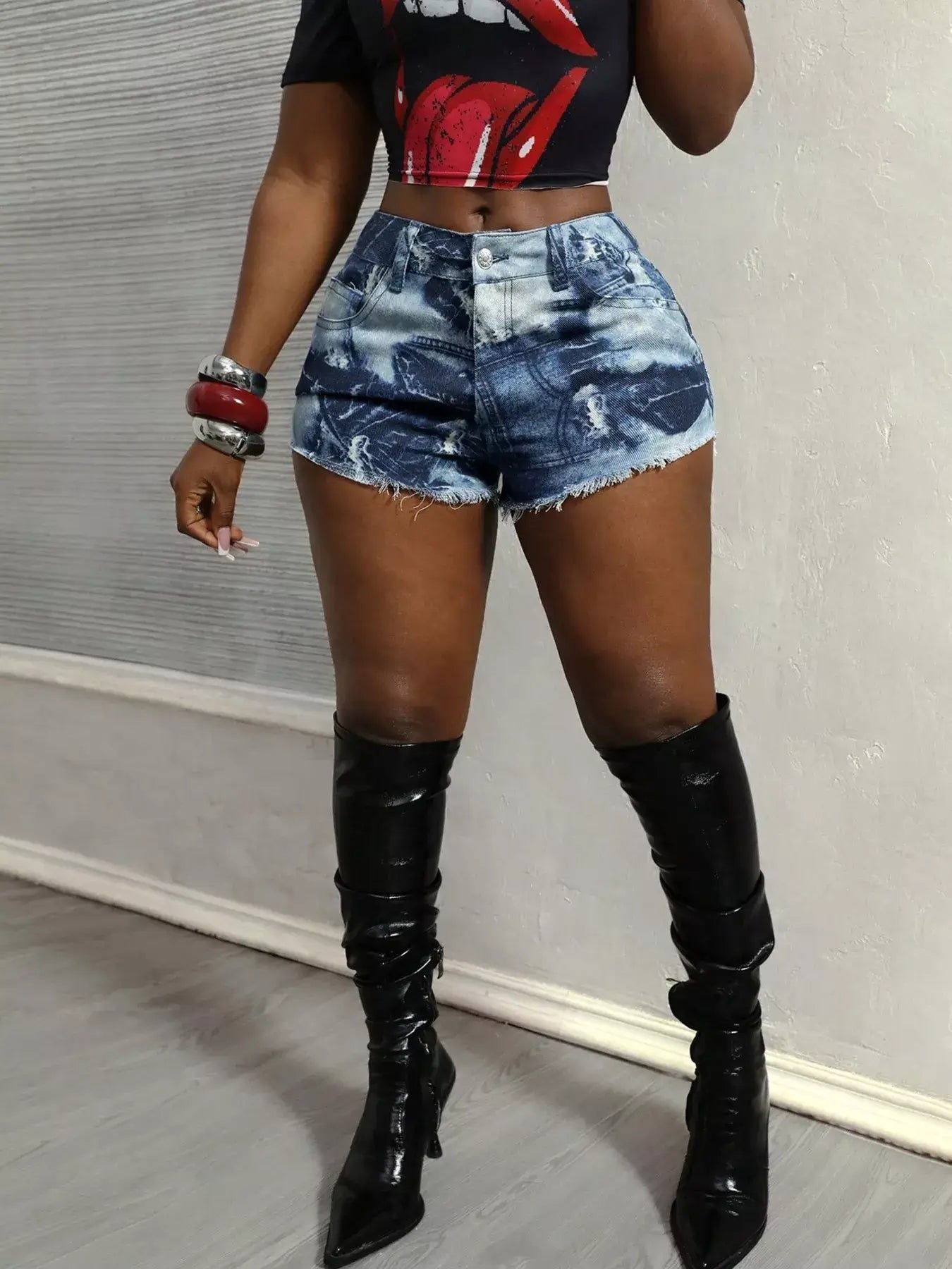 Stylish woman in trendy raw hem denim shorts and black knee-high boots, perfect for summer fashion.