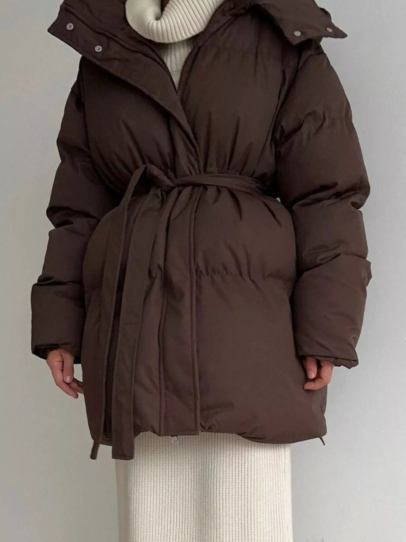 Mid Length Hooded Winter Coat Belted worn by a woman in brown, featuring a thick and warm design with pockets and a belt.