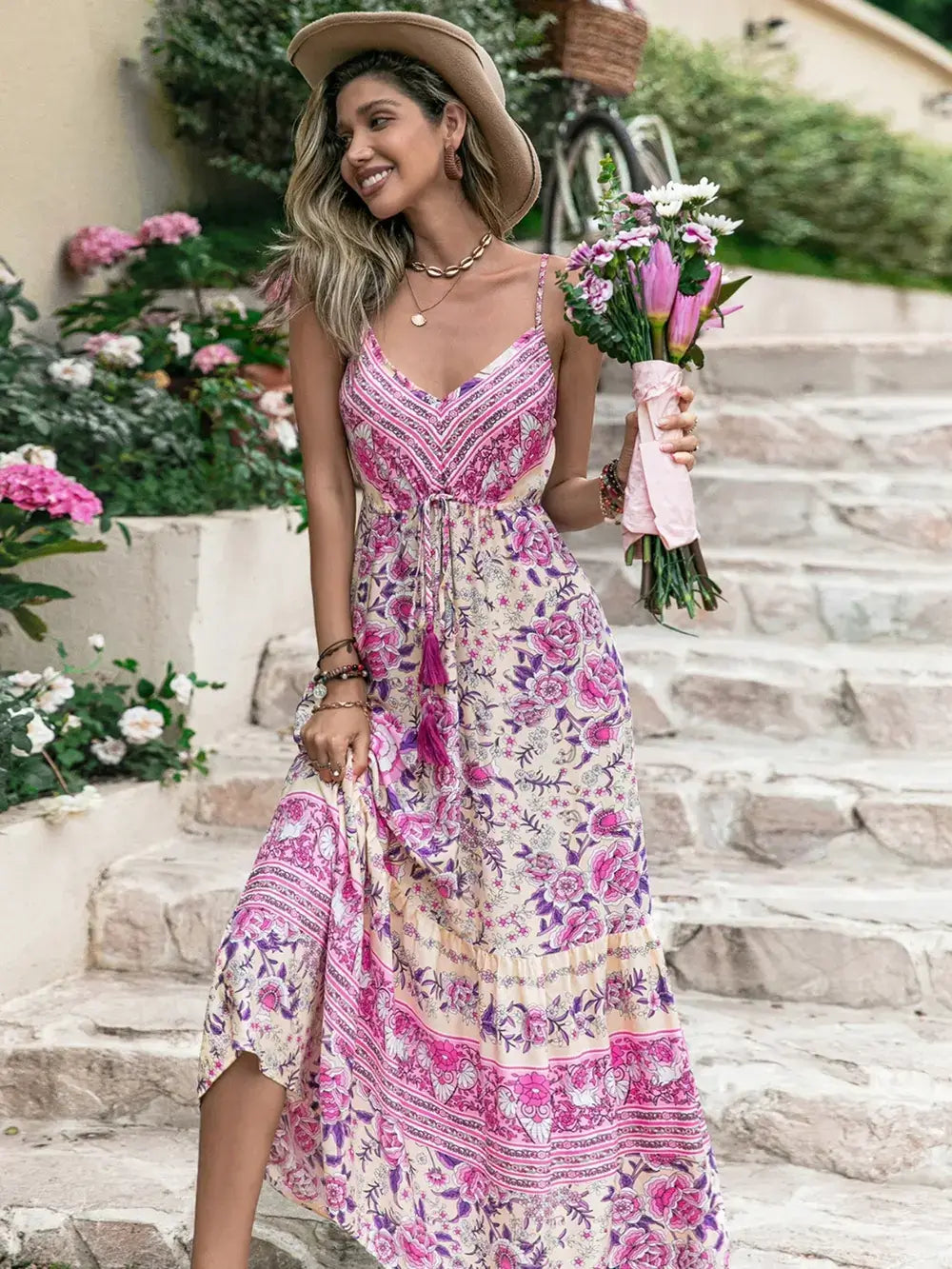 Model wearing a Tassel Printed V-Neck Maxi Dress, holding flowers, showcasing summer style.