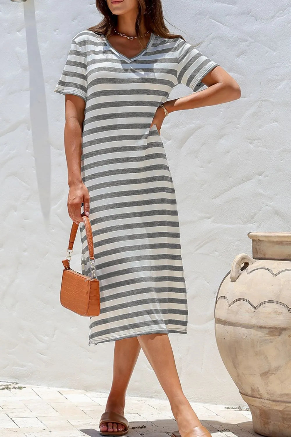 Casual Striped V-Neck Midi T-Shirt Dress styled with a handbag, perfect for everyday wear and summer outings.