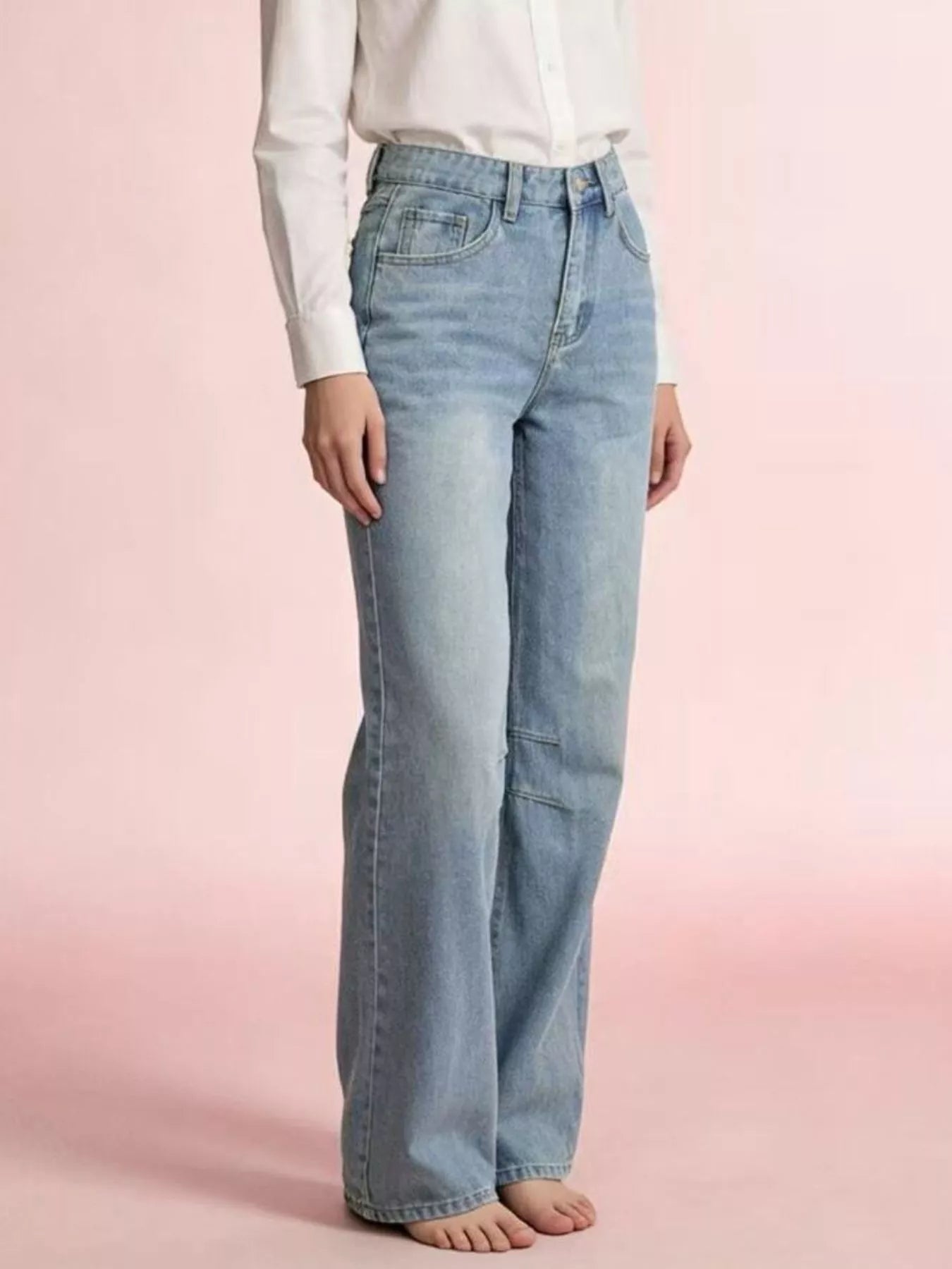 Wide Leg Wash Jeans with buttoned pocketed design in light blue, worn with a white shirt, side view.