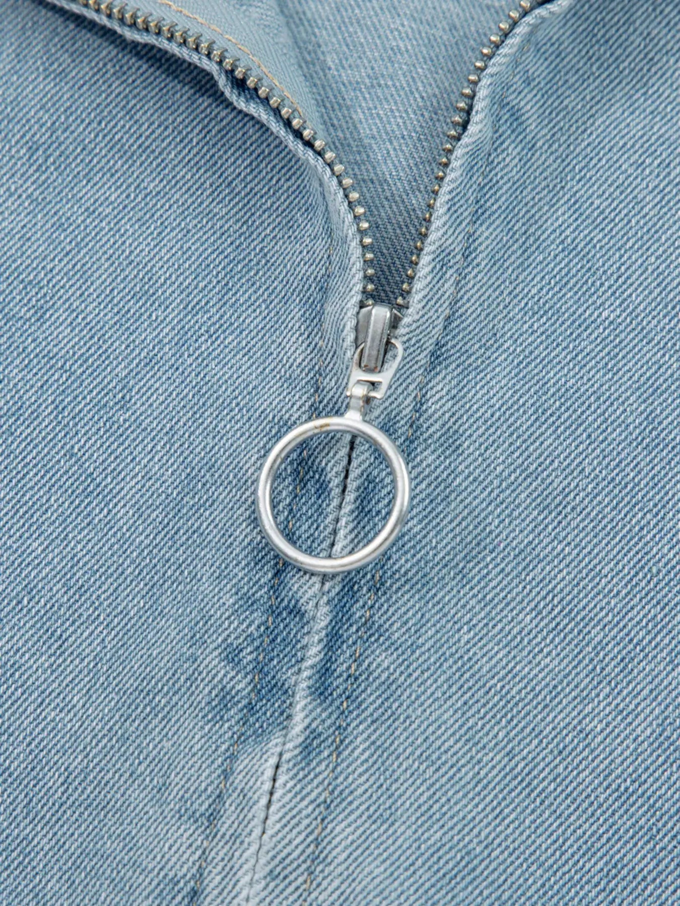 Close-up of a zip-up denim jacket showcasing the zipper and fabric texture.