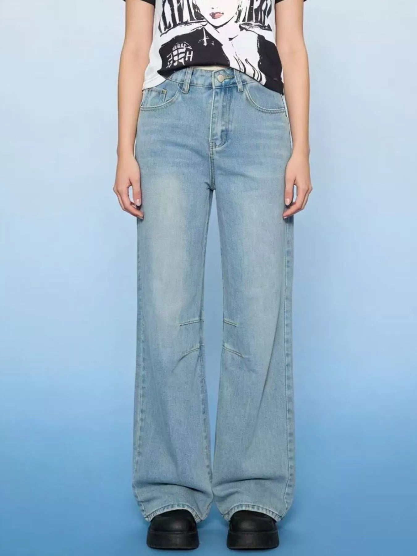 Wide Leg Wash Jeans with Buttoned Pocketed Design in light blue, worn by a model with a graphic t-shirt.