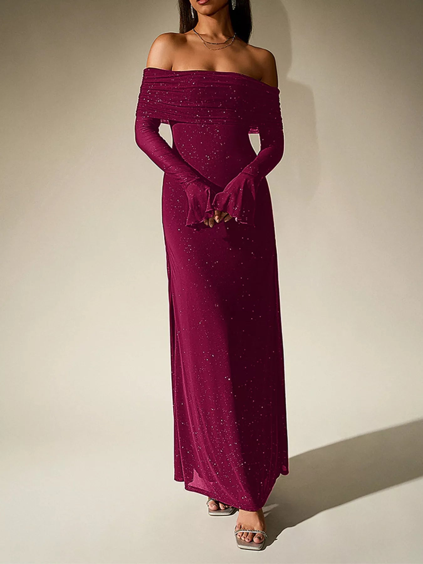 Model wearing a Glitter Off-Shoulder Maxi Dress featuring a side slit and long sleeves, perfect for elegant evening looks.