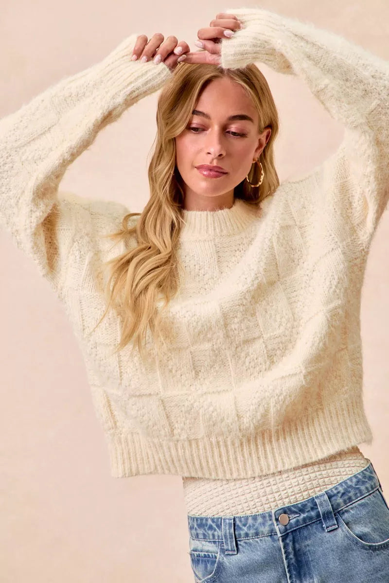 BiBi Checker Board Drop Shoulder Sweater styled with relaxed fit, showcasing a cozy cream color and textured pattern.