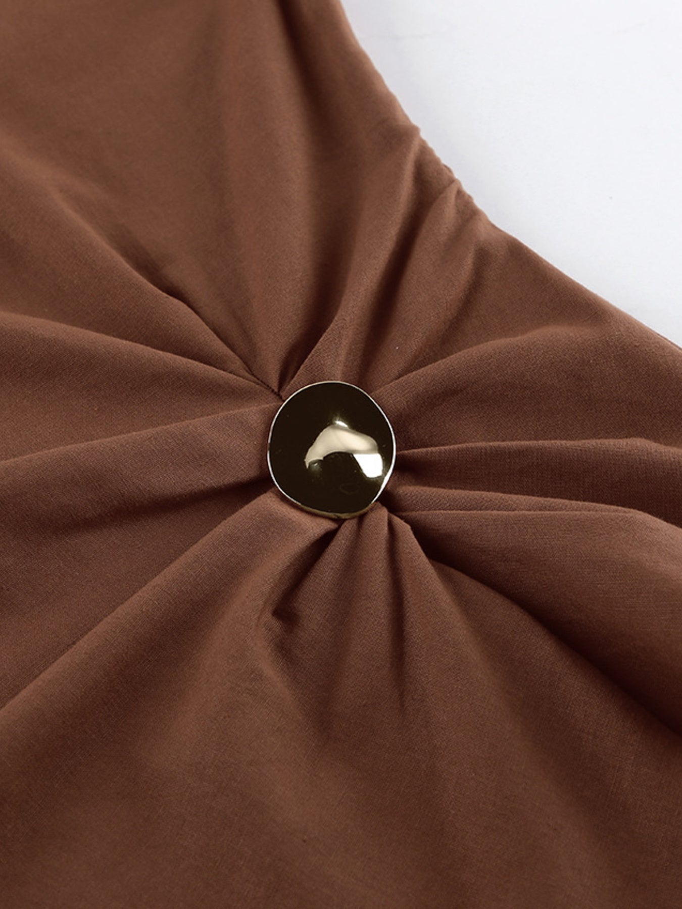 Detail of the One Shoulder Top and Shorts Set showing the ruched fabric and decorative button feature.