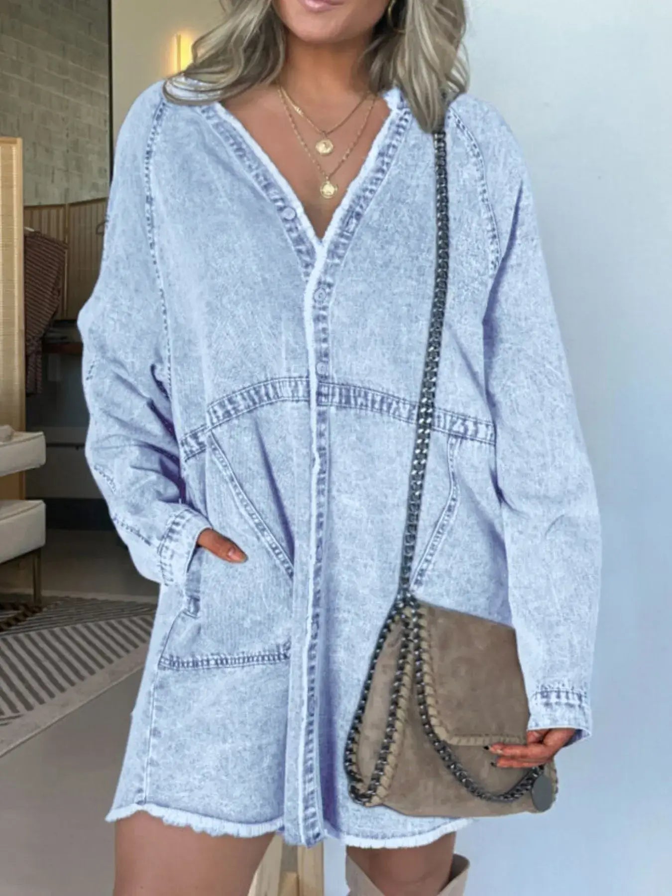 Model wearing a Full Size Button-Front Long Sleeve Denim Shirt Dress with pockets and a shoulder bag.