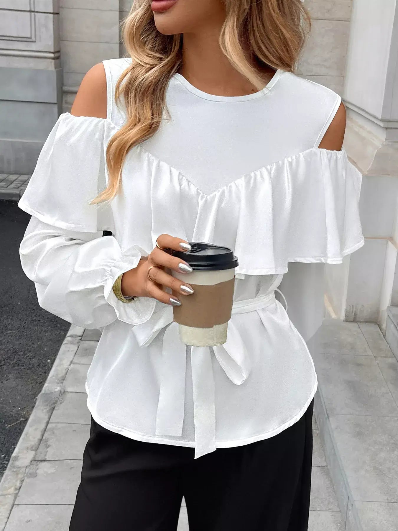 Ruffled Cold Shoulder Flounce Sleeve Blouse in white with flounce sleeves and cold-shoulder design, holding coffee cup.
