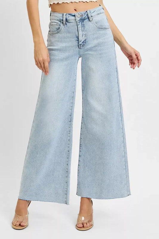 Model wearing RISEN Full Size High Rise Ankle Wide Palazzo Jeans in light blue denim, showcasing a trendy wide-leg style.