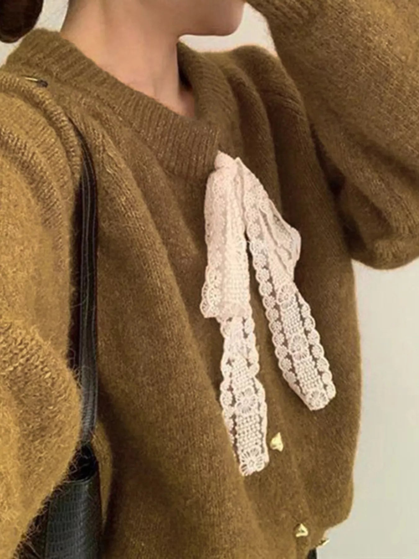Lace Bowknot Knit Cardigan featuring a delicate lace bow, slightly stretchy fabric, and buttoned design for a feminine look