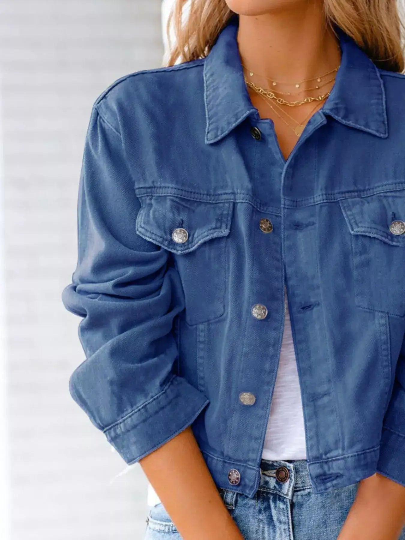 Close-up of a button-up long sleeve denim jacket for women, styled with rolled sleeves, perfect for casual outfits.
