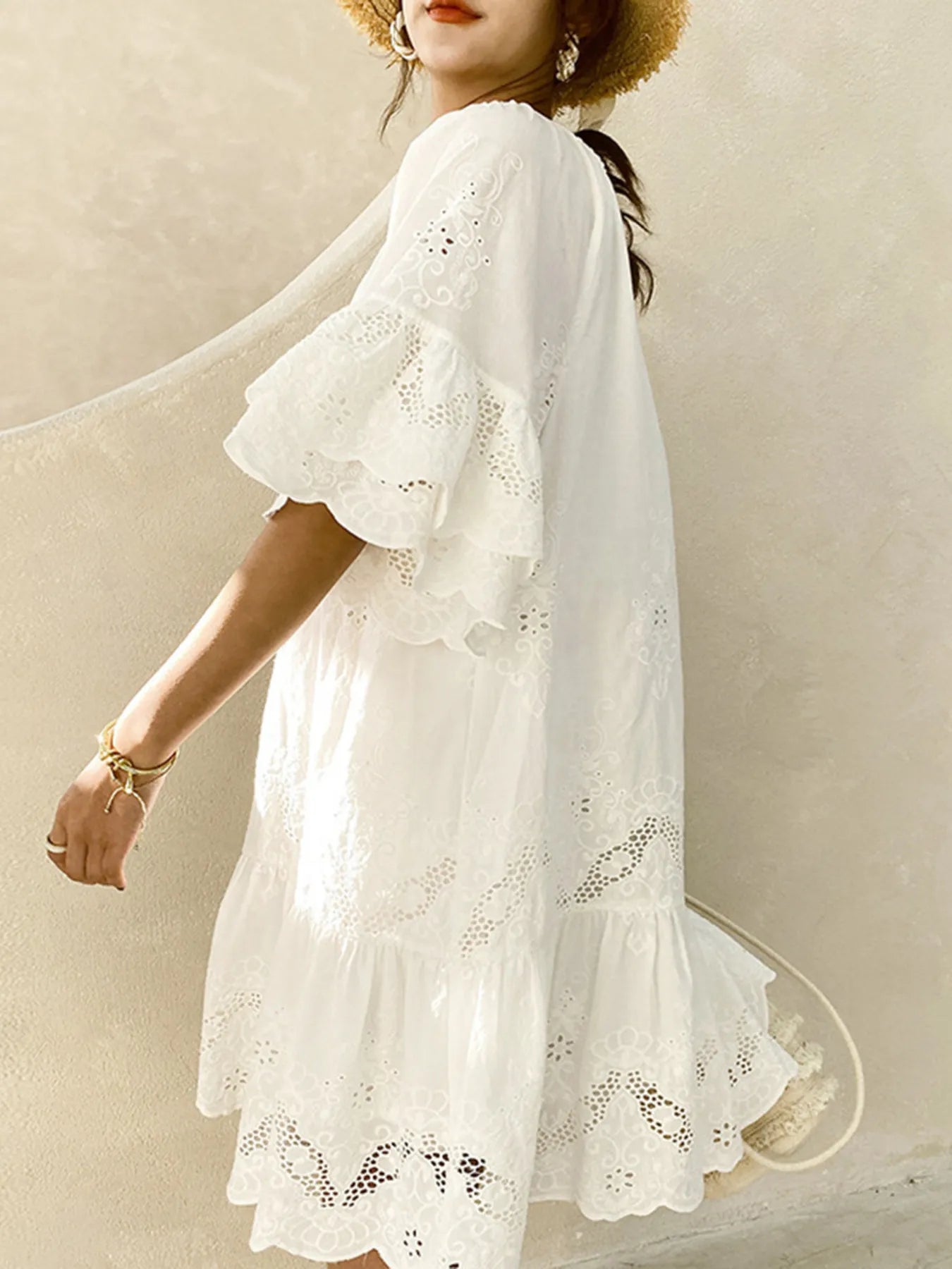 Model wearing Eyelet Embroidered Tassel Tie Neck Dress showcasing elegant ruffled sleeves and delicate embroidery.