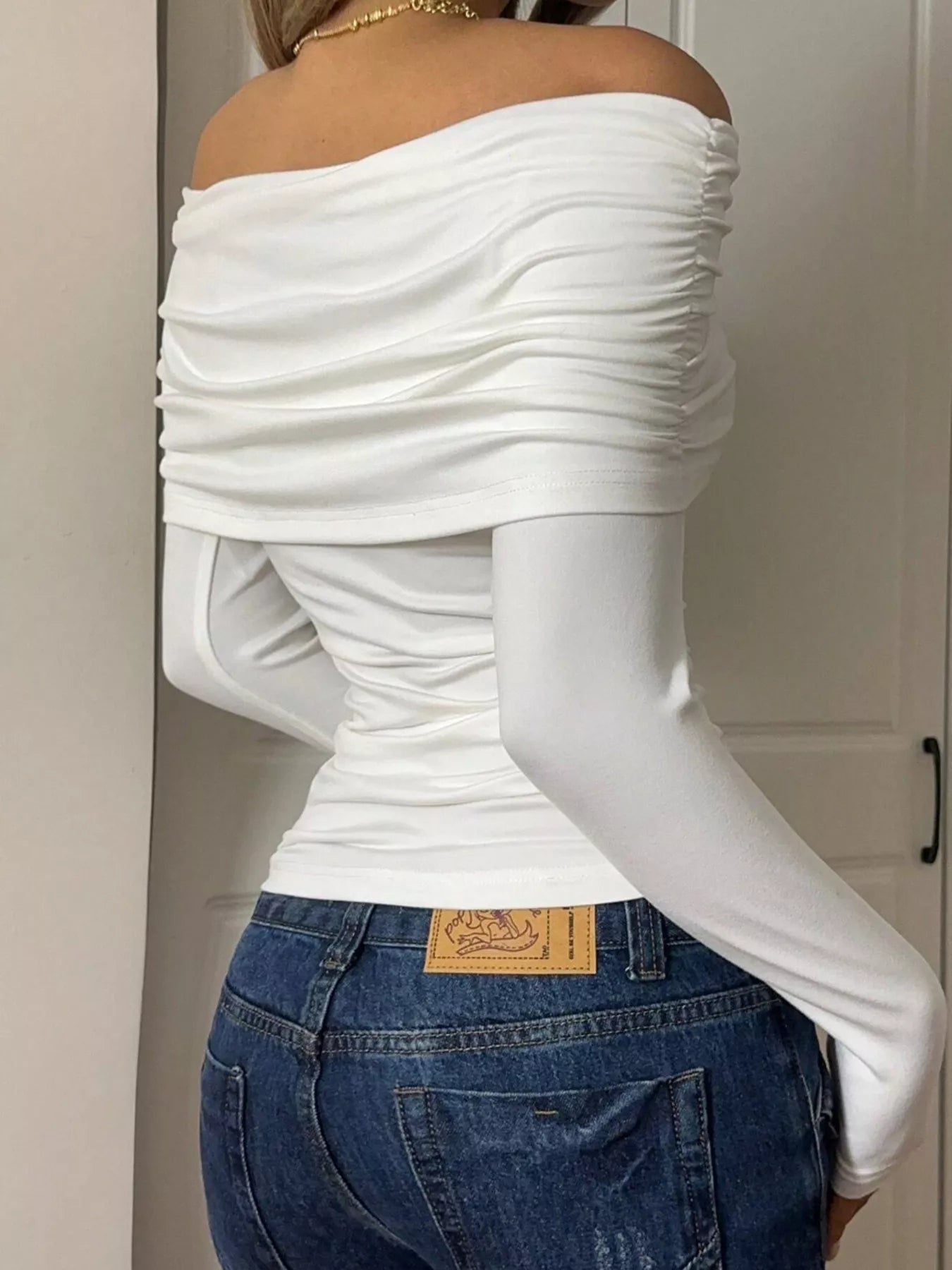 Off-Shoulder Ruched Long Sleeve T-Shirt showcasing a woman in a white ruched design with a stylish back view.