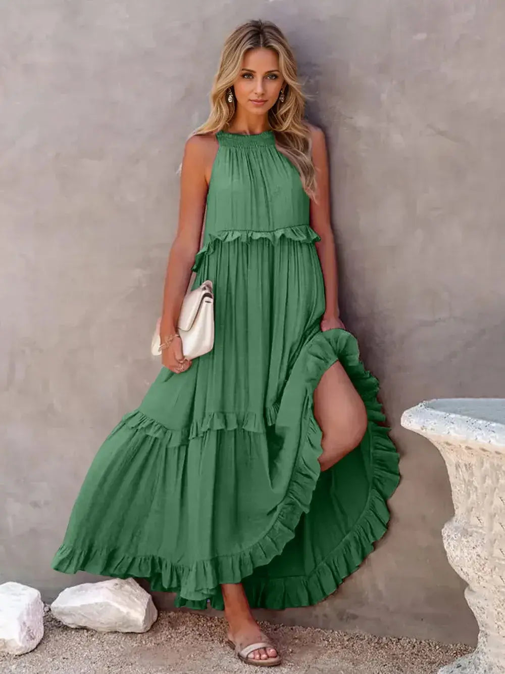 Ruffled Sleeveless Tiered Maxi Dress with Pockets worn by a model, featuring a flowing green silhouette and elegant ruffles.