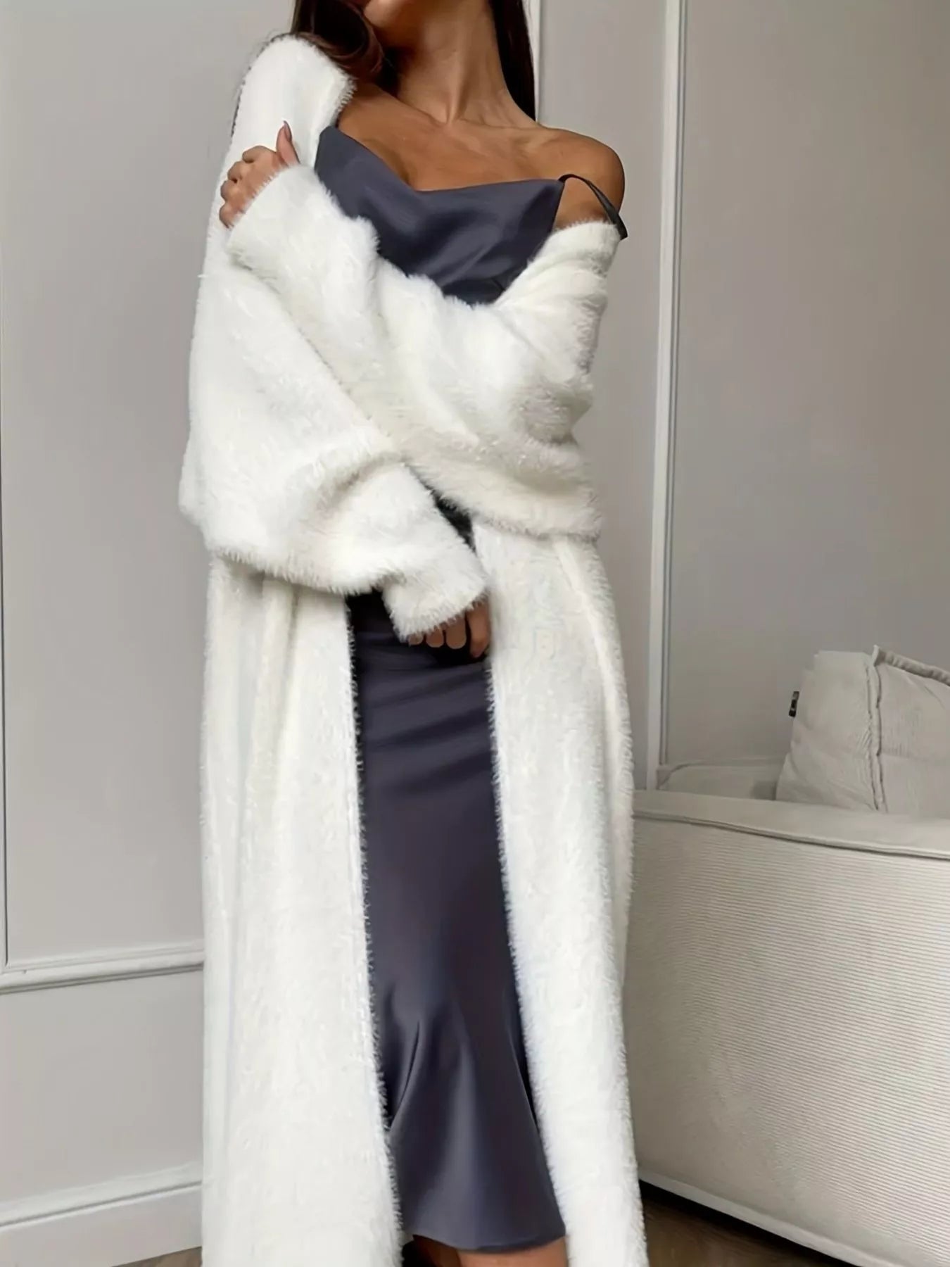 A woman wearing a Fuzzy Open Front Longline Cardigan over a satin dress, showcasing a cozy and stylish look.
