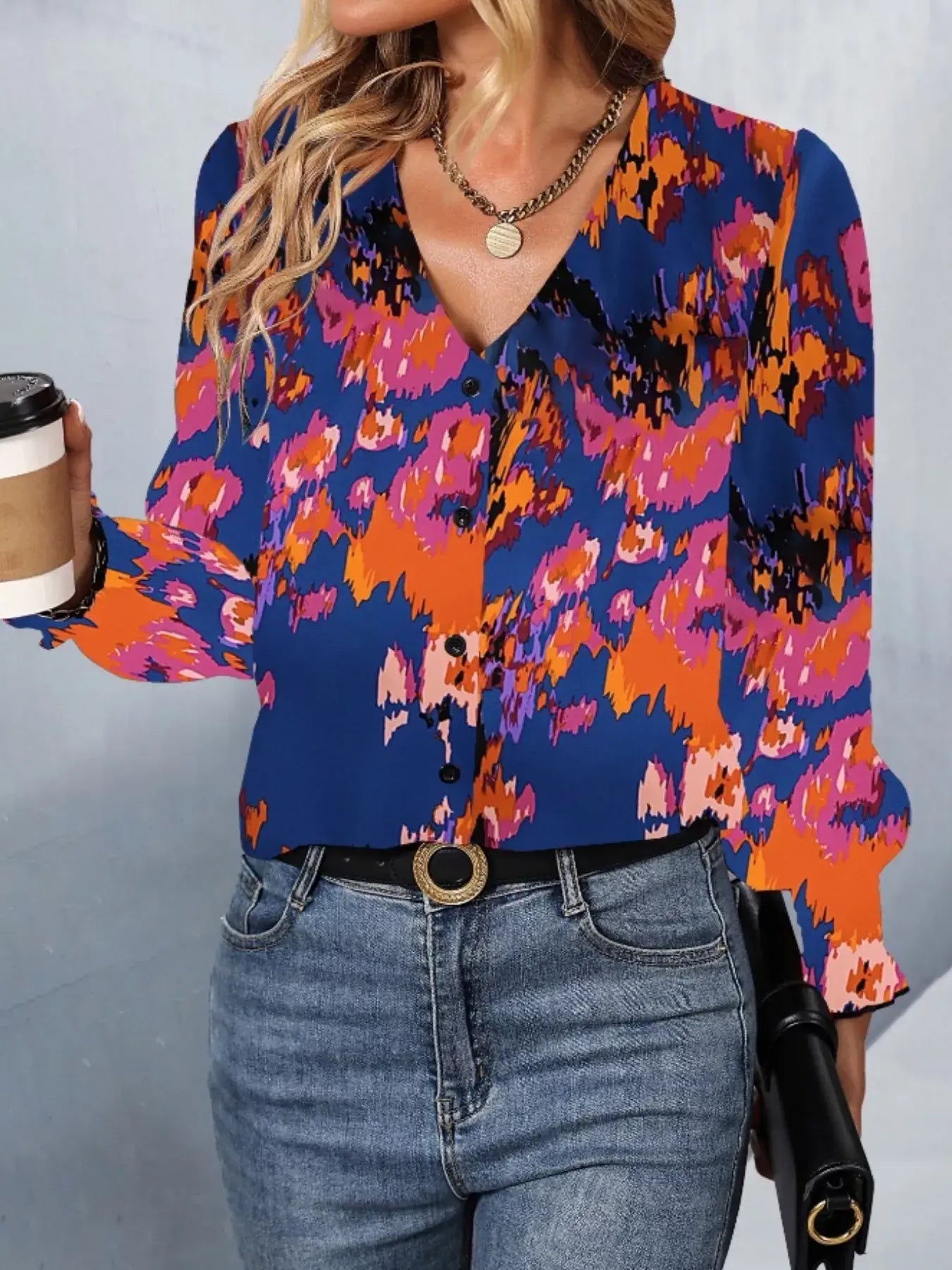 Printed button up long sleeve shirt in vibrant colors, styled for a casual look with jeans and accessories.