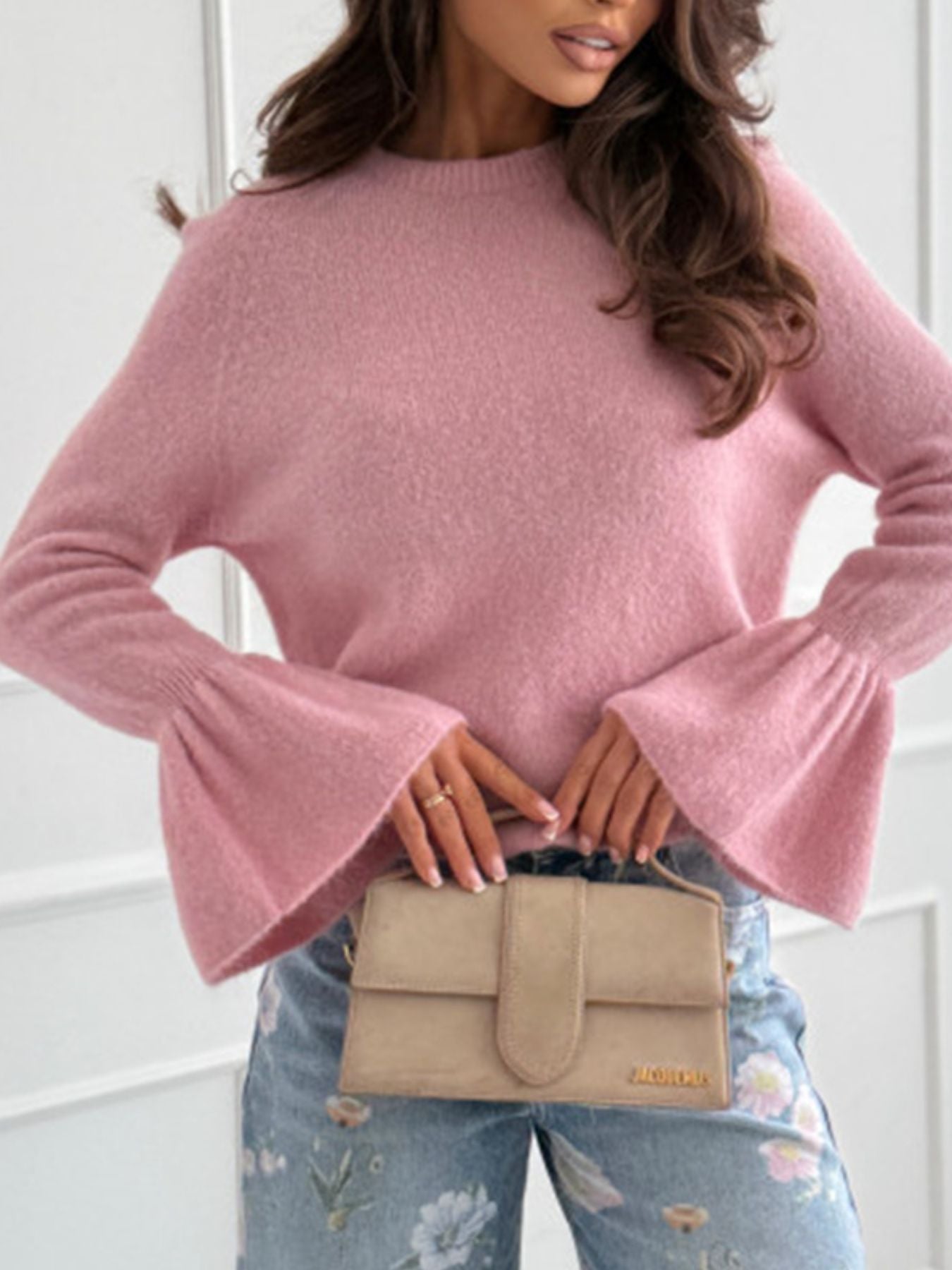 Round Neck Flounce Sleeve Sweater in pink, showcasing ribbed knit design and stylish flare sleeves, paired with a beige clutch.