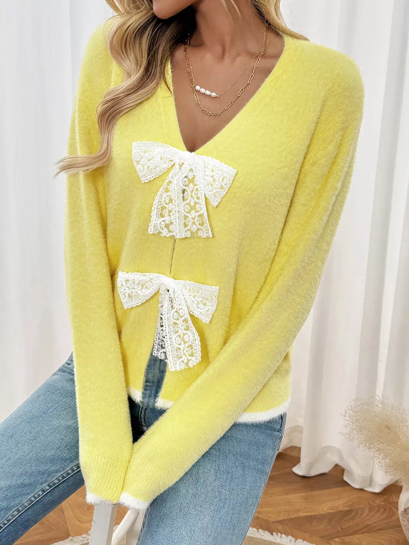 Lace Bow-Tie Front Long Sleeve Cardigan in yellow featuring lace bow details, paired with jeans for a chic look.
