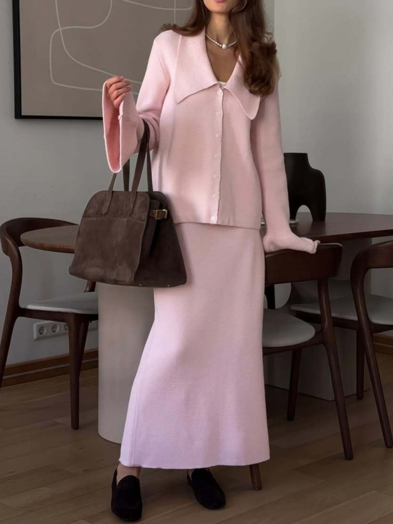 Woman modeling a Button Down Cardigan and Skirt Knit Set in pink, featuring ribbed details and a stylish shoulder bag.