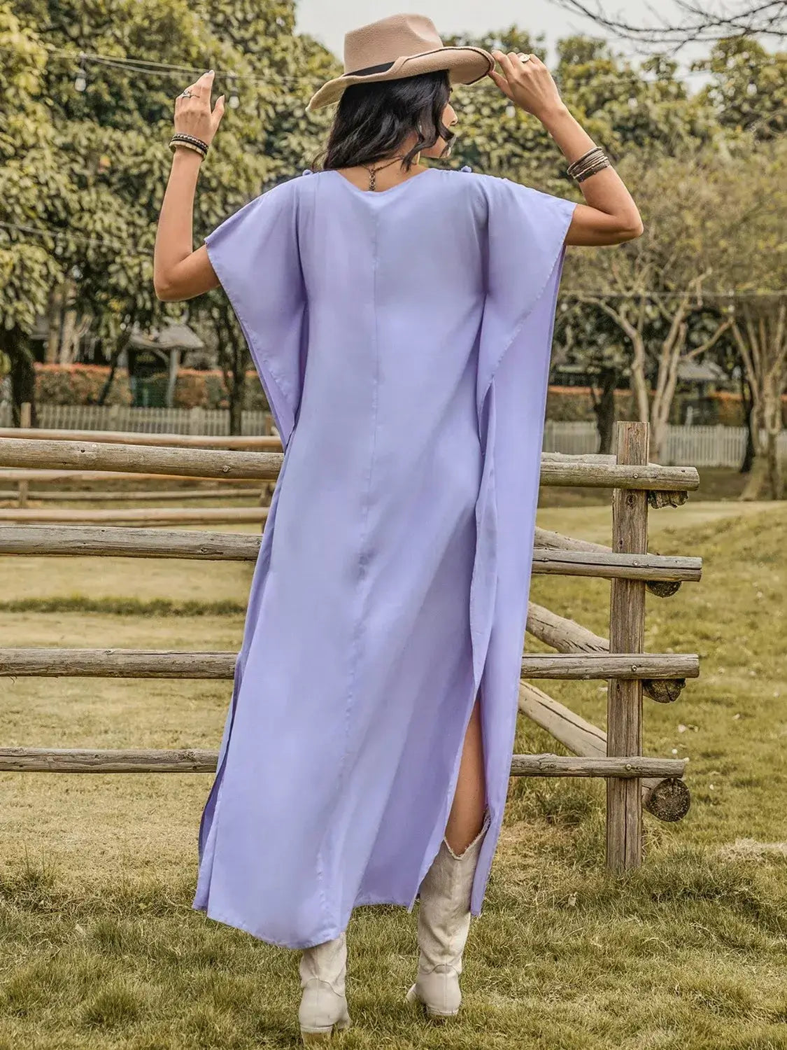 Back view of a woman wearing a Side Slit Tie Neck Flutter Sleeve Dress, showcasing its elegant design and side slit.