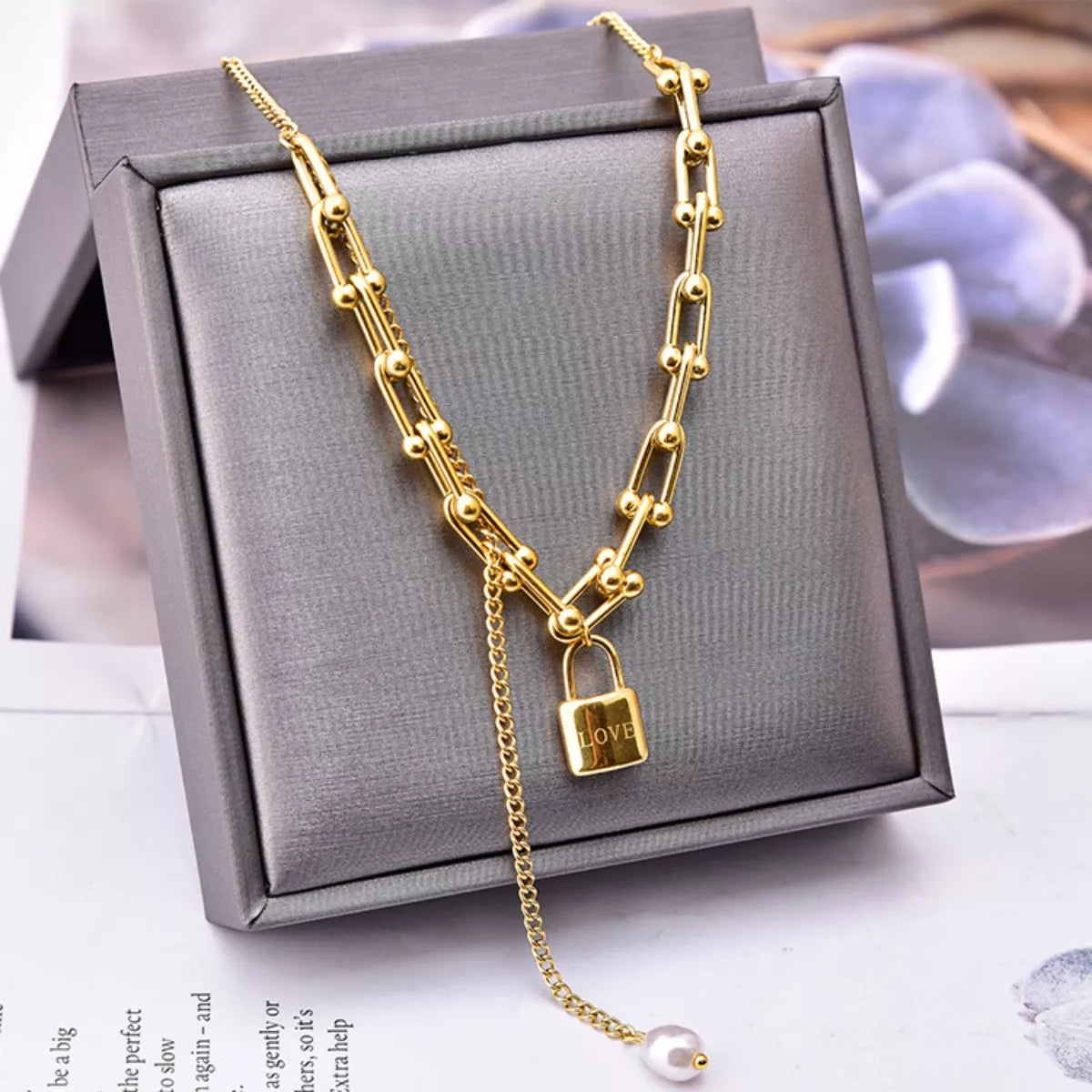 18K Gold-Plated Lock Pendant Necklace displayed on a gray jewelry box with a pearl accent.