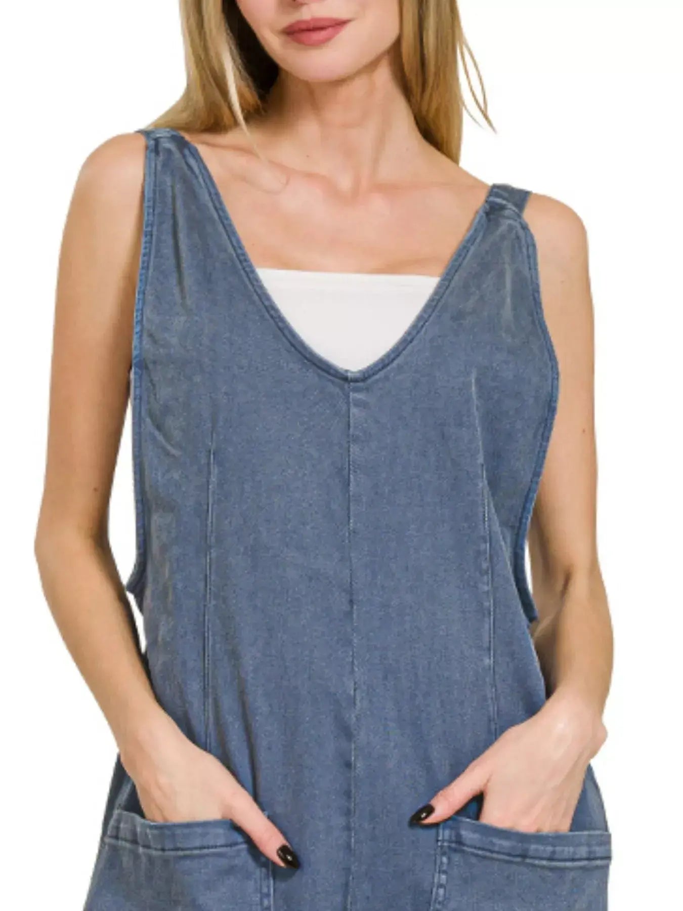 Woman wearing a Zenana Casual Adjustable Strap Baggy Jumpsuit in denim with pockets and a relaxed fit.