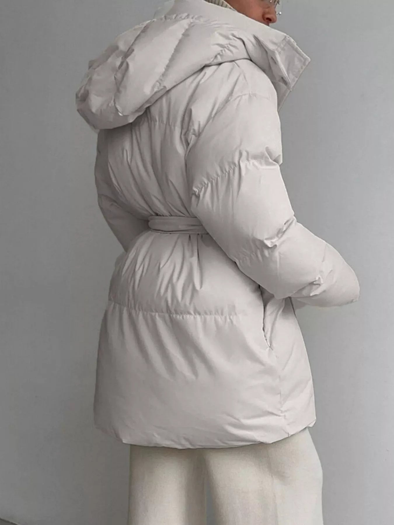 Mid Length Hooded Winter Coat Belted shown from the back, featuring a soft cream color and belted waist for a stylish winter look.