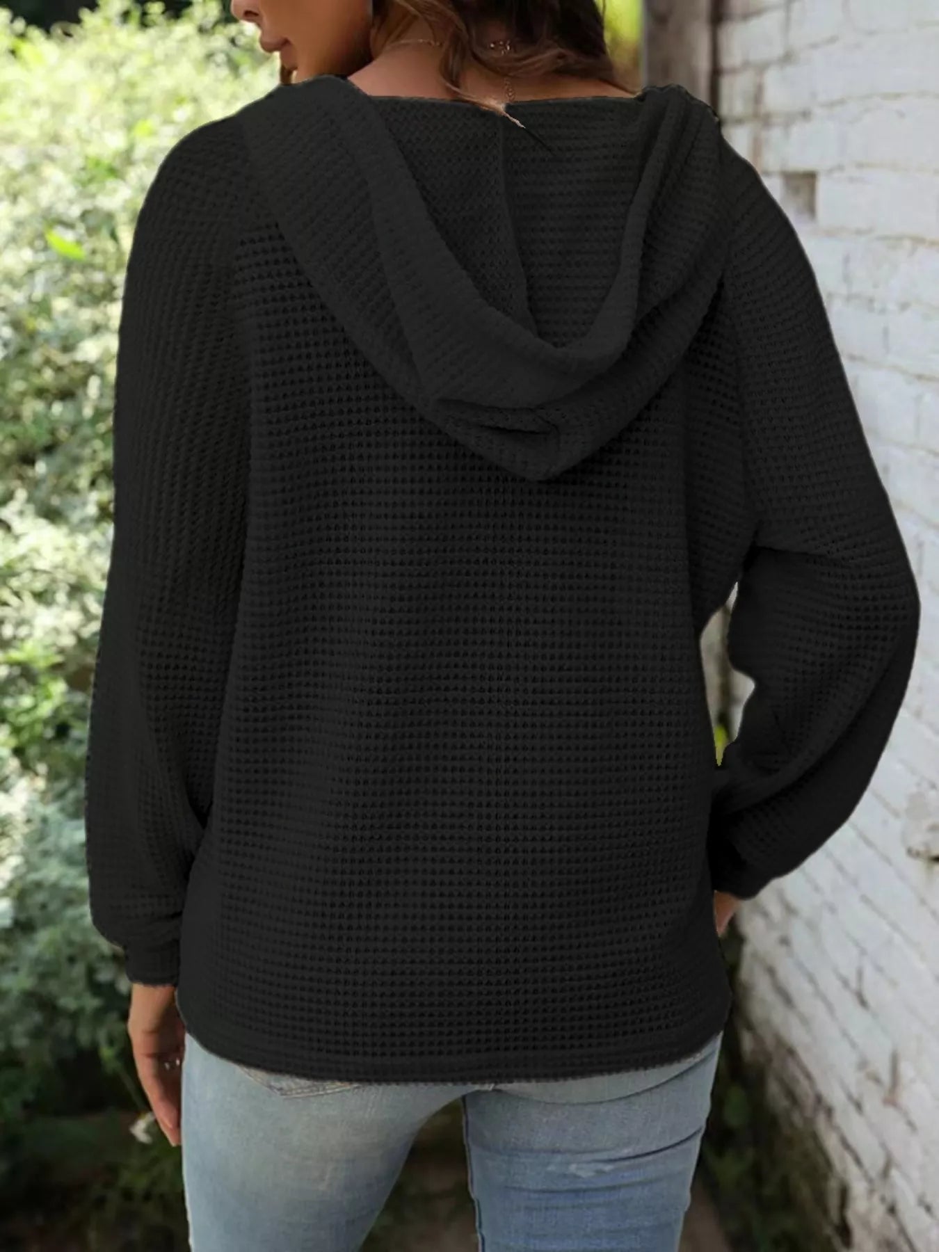 Back view of a woman wearing a Full Size Button Detail Waffle Knit Hoodie Plus Size in black.