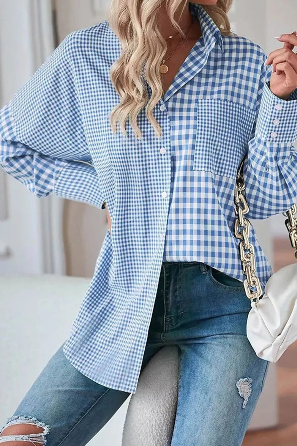 Woman wearing a plaid button up long sleeve shirt in blue with pocket, paired with denim jeans for casual style.