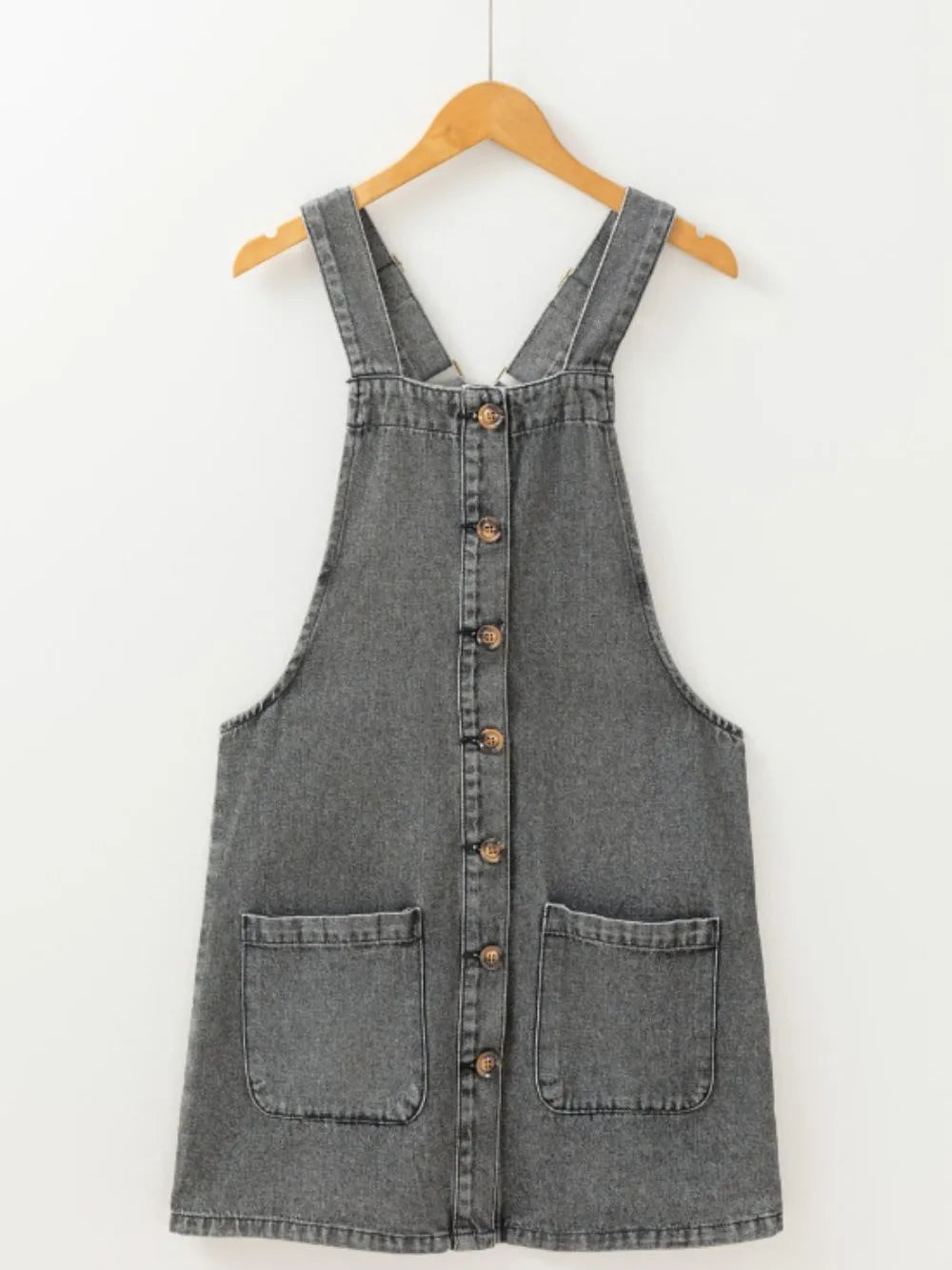 Wide Strap Button Down Denim Overall Dress displayed on a hanger, featuring a button front and pockets.