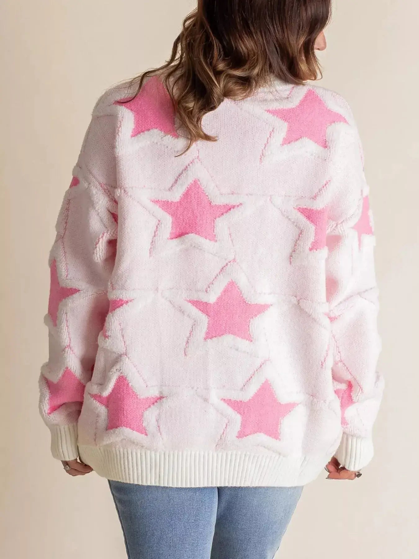 Oversized star pattern ribbed edge drop shoulder sweater in pink and white, showing back view with star design.