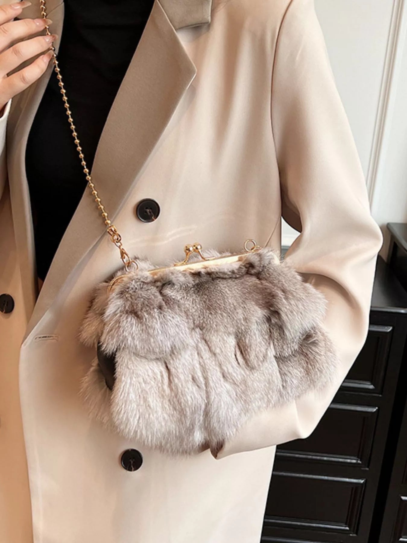 Furry Chain Crossbody Bag in fox fur held by a person wearing a beige coat, perfect for trendy casual looks.