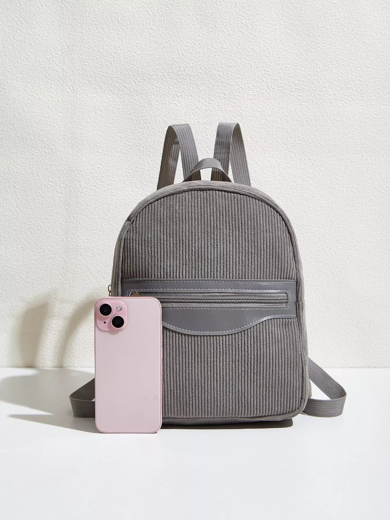 Casual Corduroy Backpack Bag in gray color with a pink phone beside it for daily urban use.