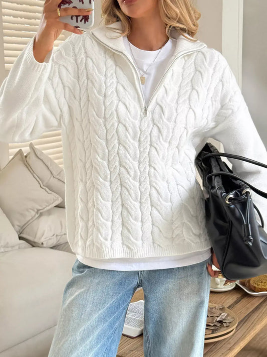 Model wearing a zip collar cable-knit sweater in white, showcasing its cozy texture and stylish design.