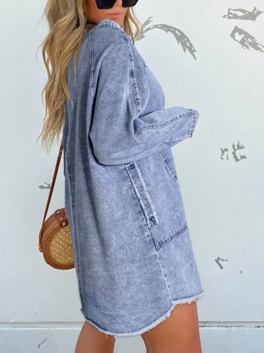 Model showcasing a full size button-front long sleeve denim shirt dress with pockets, styled casually with sunglasses and a bag.