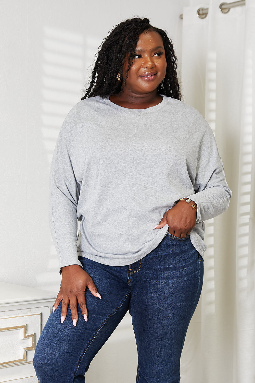 Double Take Seam Detail Round Neck Long Sleeve Top for Women in light gray with a relaxed fit, paired with blue jeans.