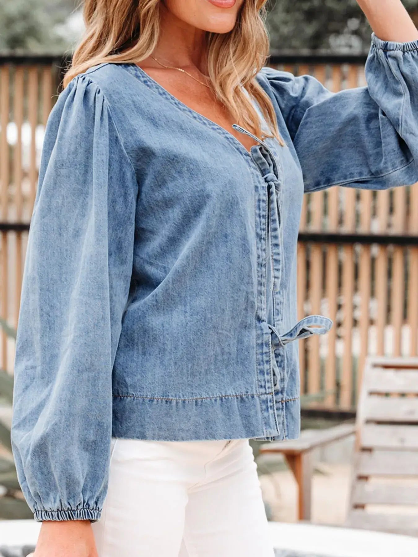 Tied front puff sleeve denim top for women, stylish jean blouse, casual chic outfit with dramatic sleeves.