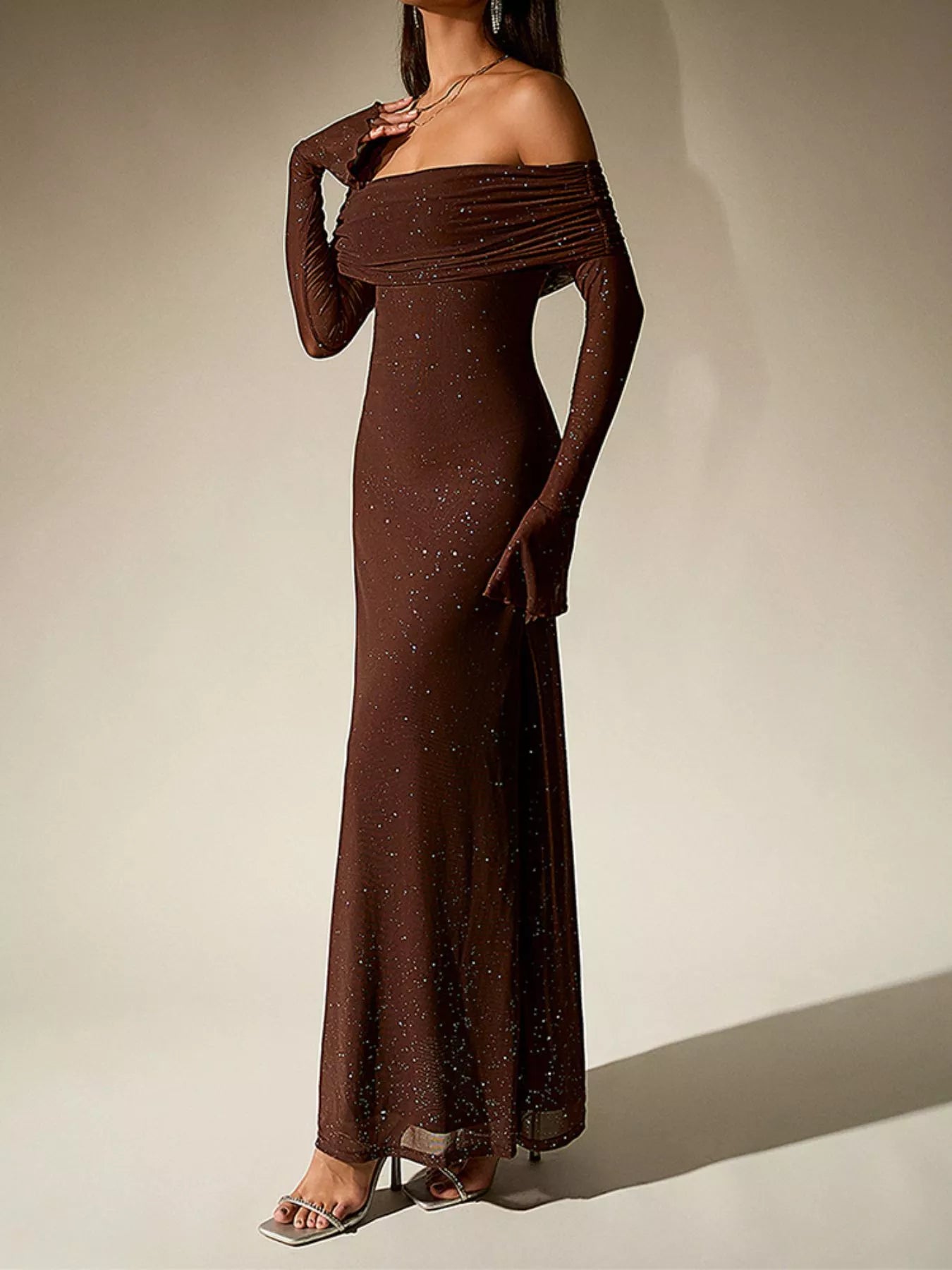 Model wearing a Glitter Off-Shoulder Maxi Dress showcasing glitter detail, perfect for elegant evening looks.